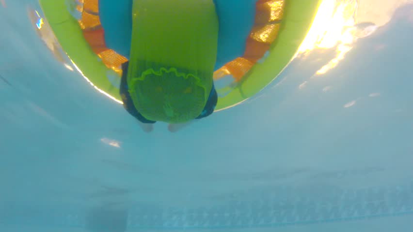 Underwater shot of a cute little baby boy at the swimming pool with his family.