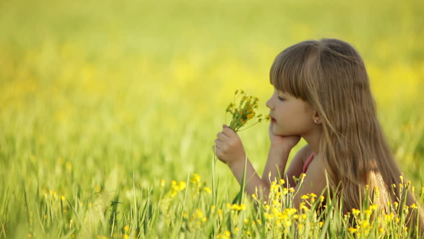 Pretty girl sniffing flowers and smiling
