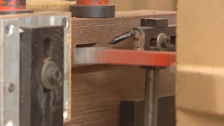 Hole cutting in a wooden board with saw machine - extreme close up