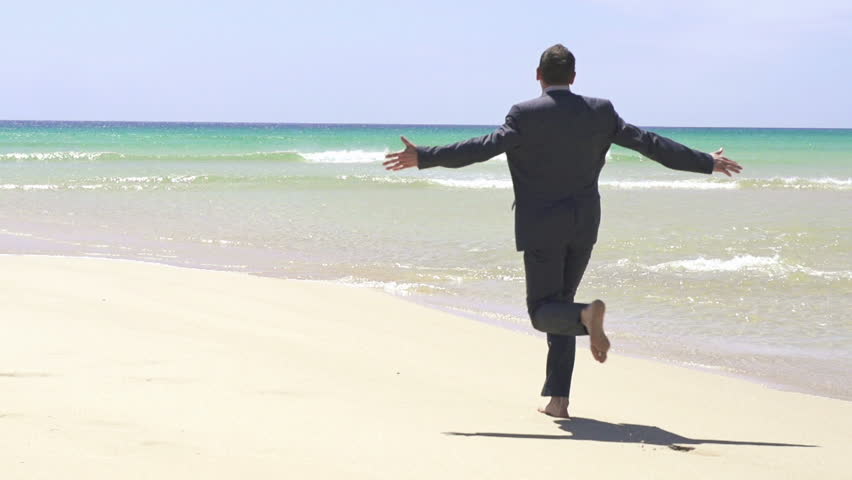 Excited businessman running on the beach, super slow motion, shot at 240fps
