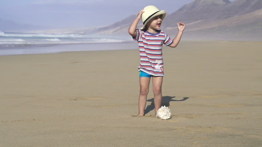 Boy with beautiful seashell on the beach, super slow motion, shot at 240fps
