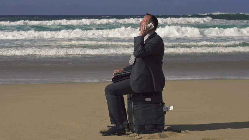 Businessman talking cellphone on beach, super slow motion, shot at 240fps
