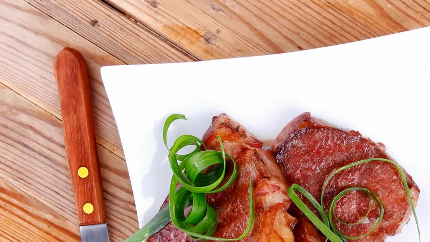 grilled meat beef steaks strips plate with pepper and cutlery over wood table 1920x1080 intro motion slow hidef hd