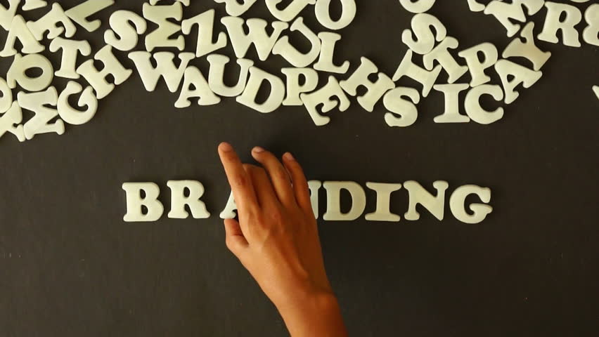 A person spelling Branding with plastic letters