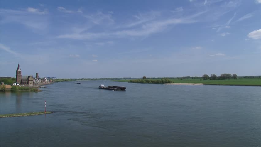 Towboat pushing barges downstream on river Rhine at Emmerich, Germany.