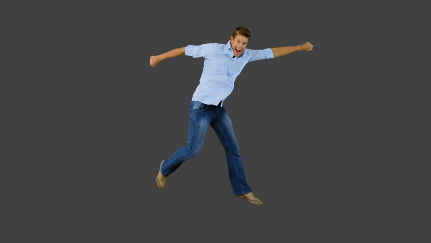 Man jumping and gesturing on grey screen in slow motion