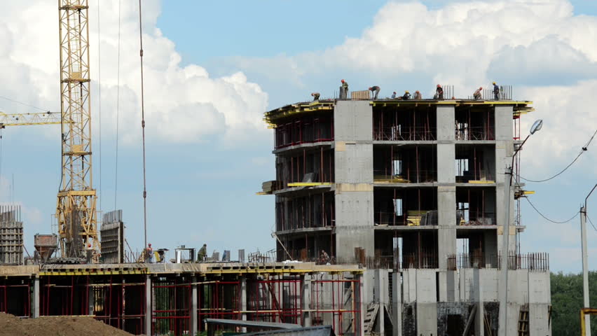 Construction of concrete buildings on background moving clouds in Moscow area