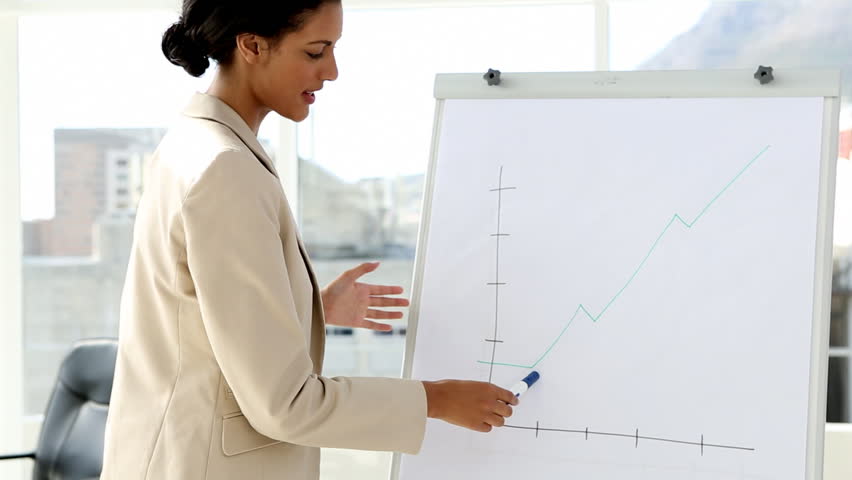 Businesswoman giving presentation in office with large window