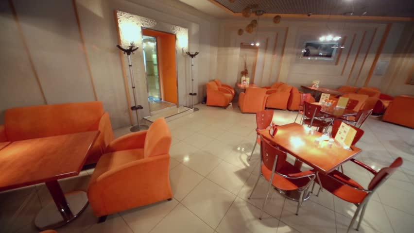 Chairs and tables in empty cafe-bar in orange tones, (panoramic motion)