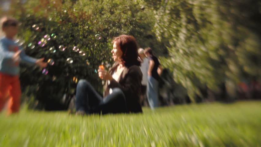 Sequence of soft focus shots. Happy Mum with the little girl playing in the park