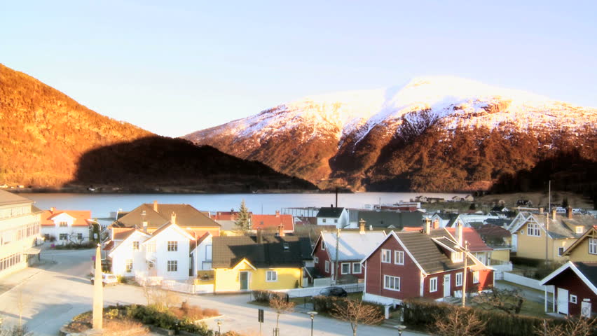 Wooden dwellings of a small town beside a glacial fjord