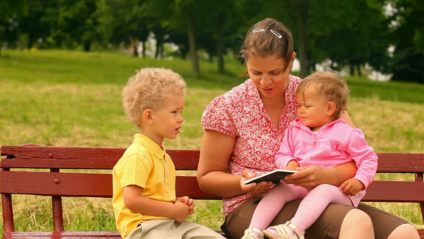 mother and two children, reading and watching Tablet Computers