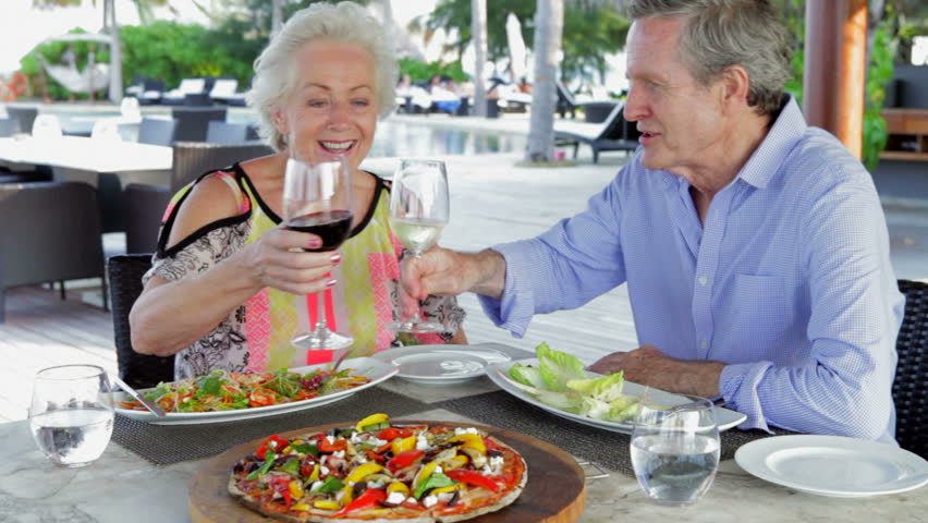 Senior Couple Enjoying Meal In Outdoor Restaurant
