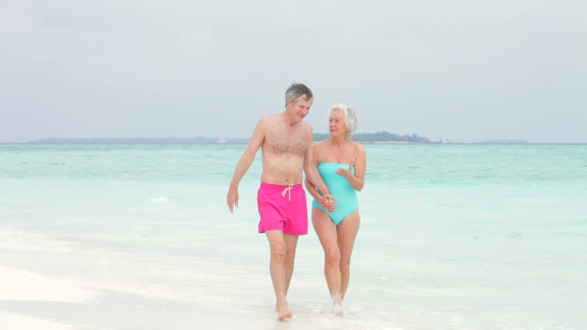 Senior Couple Walking On Beautiful Beach
