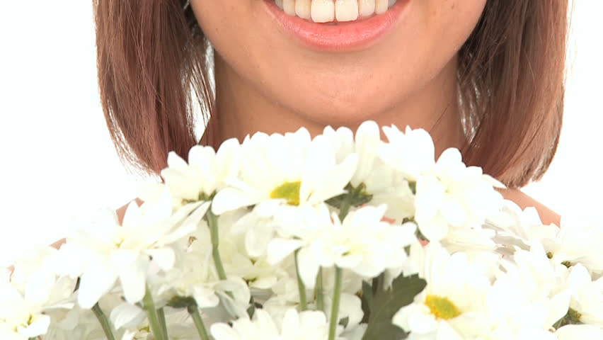 Young western oriental girl enjoying the therapeutic aroma of flowers