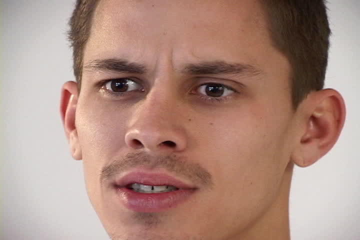 A young male adult is in a quandary with signs of doubt and perplexity.  Tight close-up on face shot with fixed focus with a tripod on miniDV.