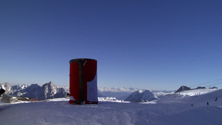 A skier rides an obstacle in the funpark and a skier jumping filmed from behind