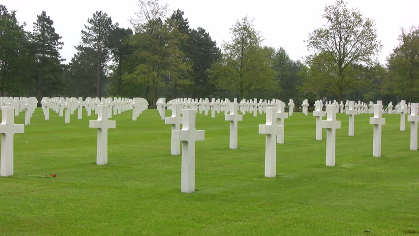 Pan of white crosses and graves at The Normandy American Cemetery and Memorial at Omaha Beach, Normandy, France.