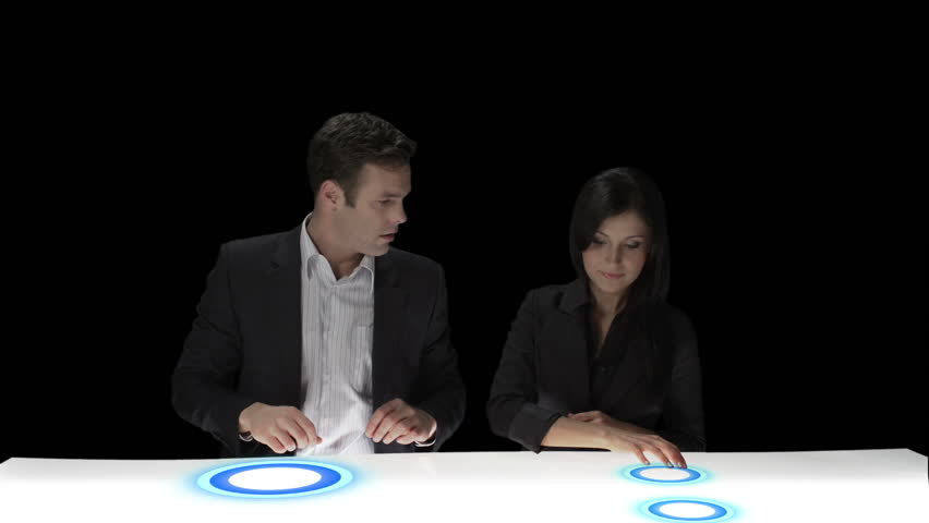 Two business people use a new technology to pull up various pictures of models they may want to use for a shoot. Medium shot