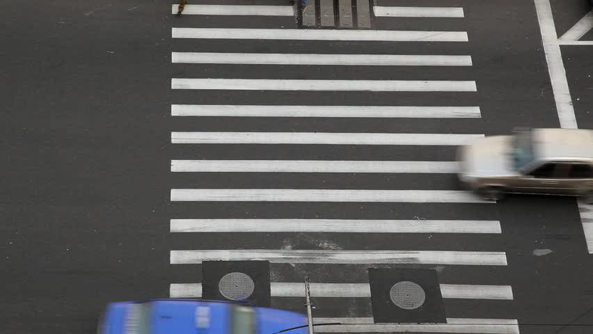Time lapse of people and vehicles at pedestrian crossing intersection on busy road in central Shanghai, China