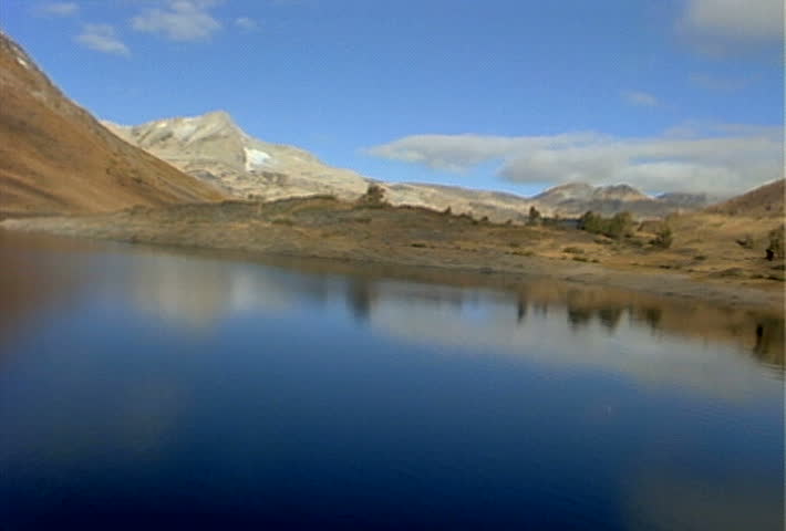 Flying just above the reflective surface of a small lake, high in the Sierra Nevada Mountain Range.