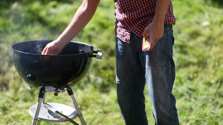 Grilling at summer weekend. Man preparing the grill.