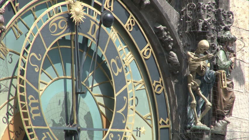 Zoom out from close-up of astronomical clock on gothic Old Town Hall tower in Prague to general view to Old Town Square. Zoom out.