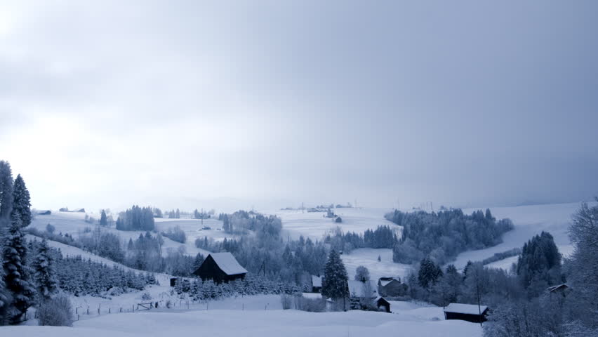 Hills, barns and forest in a moving winter postcard (time-lapse)