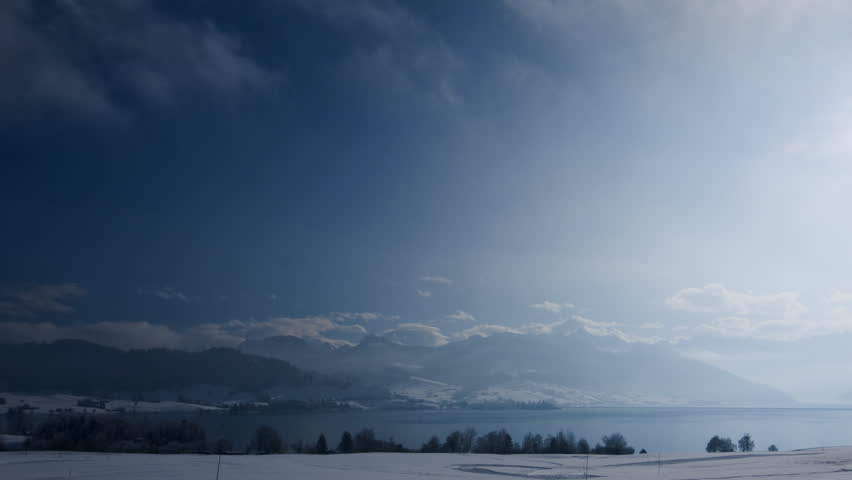 A moving christmas postcard (timelapse): winter hills and a lake in Switzerland
