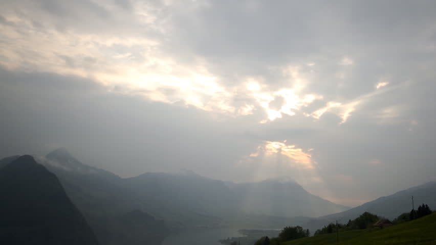 sun rays enter through the clouds. Light falls into a mystic valley. time-lapse. moving postcard.