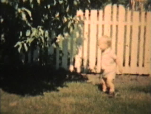 A little toddler plays with his Grandma in the back yard in 1963. (Vintage 8mm film footage).