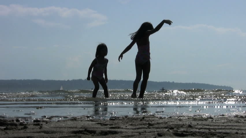 Little girls dancing and doing ballet in the surf on a glorious sunny summer afternoon.