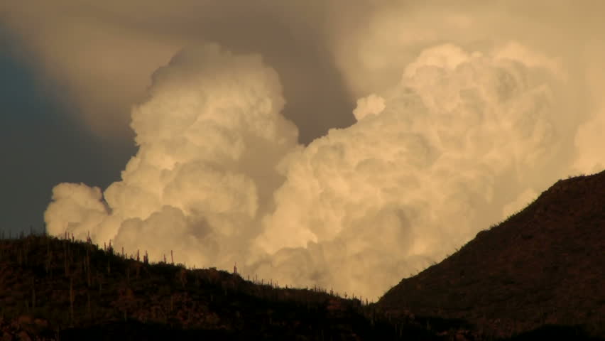 Time lapse, cloud sunset. Dramatic, fiery clouds engulf desert landscape at sunset.
