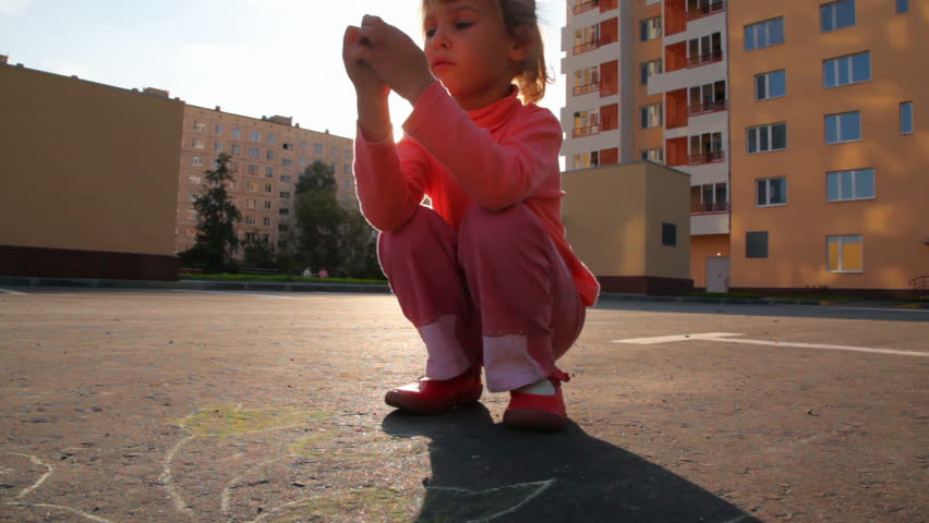 little girl chalking on asphalt 