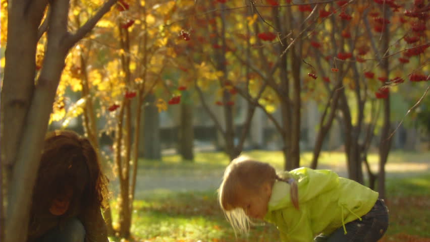 Sequence of slow motion shots happy mum and the little girl throw autumn leaves.