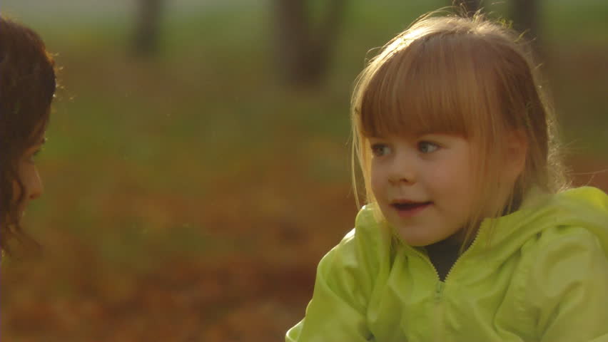 Sequence of slow motion shots of the happy mum and the little girl throw autumn leaves.