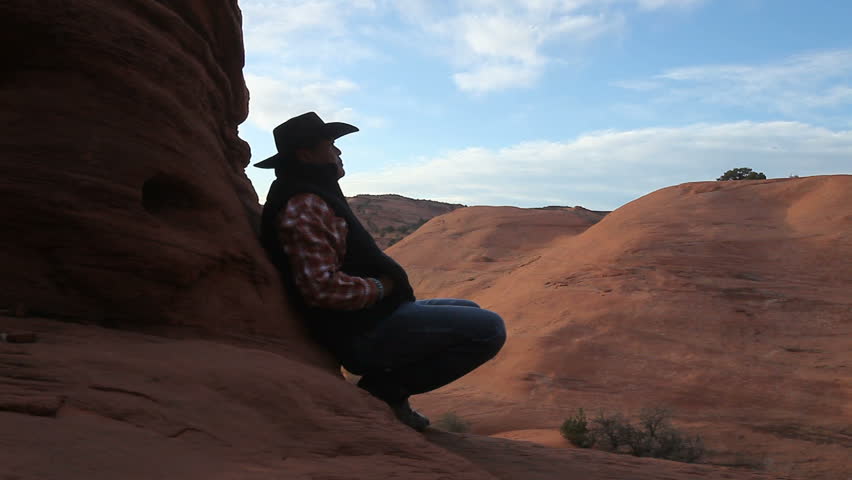 Navajo Cowboy Sitting on Rocks Looking On