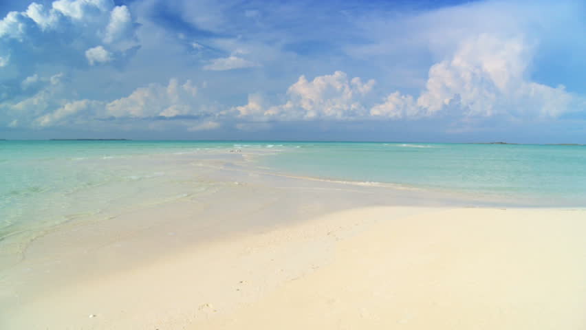 Elegant young female walking on a beautiful white sandy beach looking at aquamarine waters 60 FPS