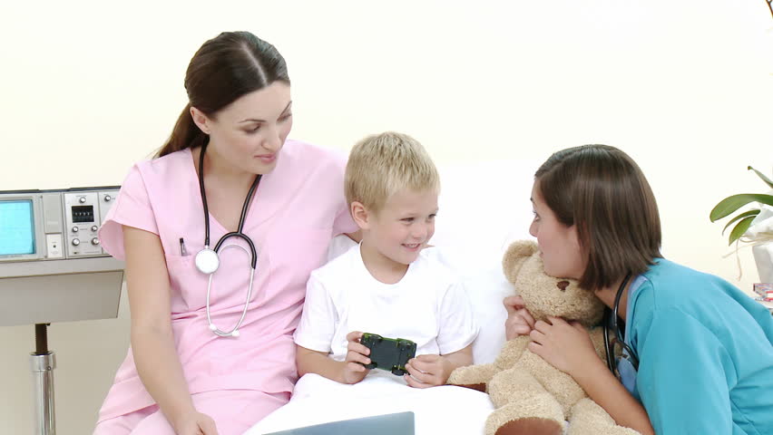Little patient talking to a nurse and a pediatrician while he is recovering in hospital. Footage in high definition. Concept of healthcare 