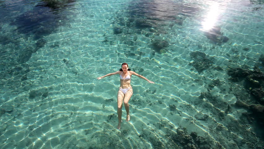 Young woman snorkeling in clean green water