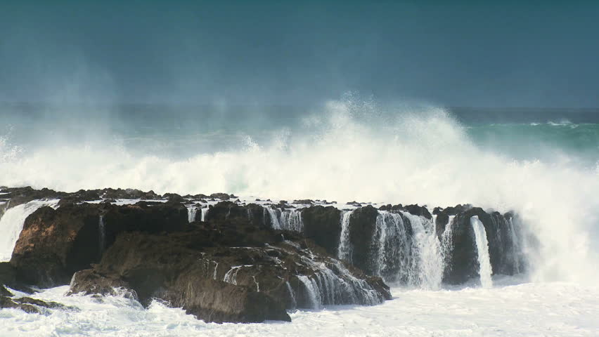 Giant breaking waves driven by high winds breaking over dangerous rocky shoreline