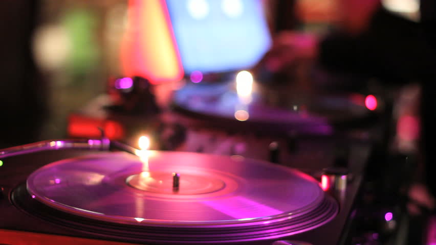 DJ Spinning, Mixing, and Scratching in a Night Club