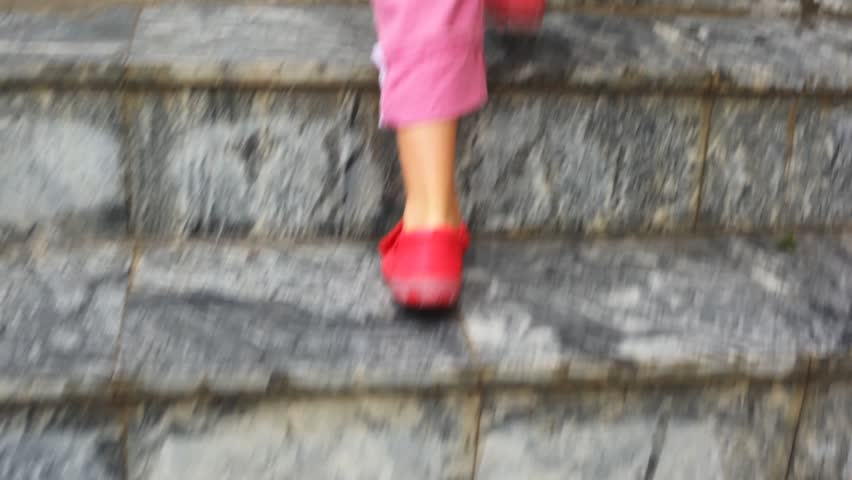feet of child walking up on ladder steps, camera follow child 