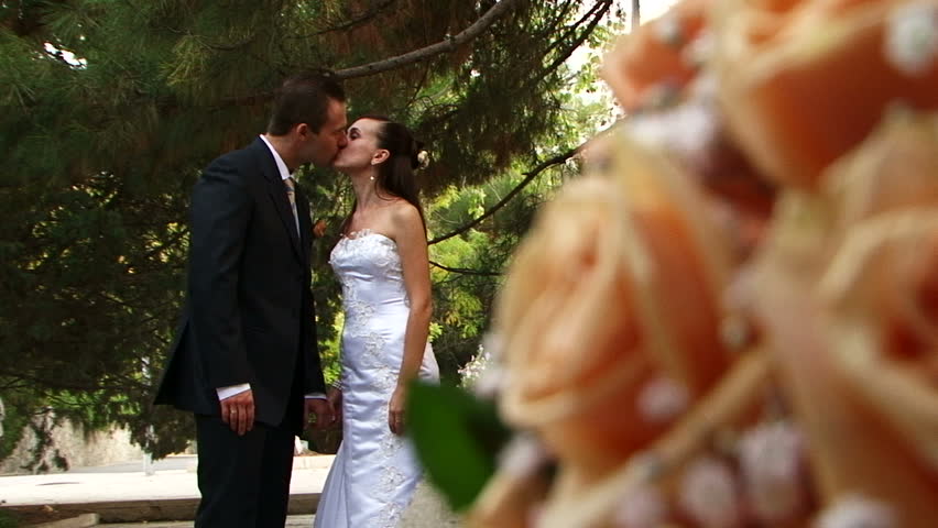 Bridal bouquet. Moving camera. Two frame. The bride and groom on the beach. 