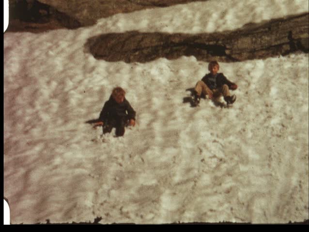 Boys gliding on snow field (vintage 8 mm amateur film)