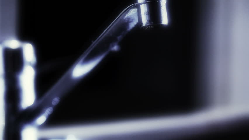 Person filling glass from water tap