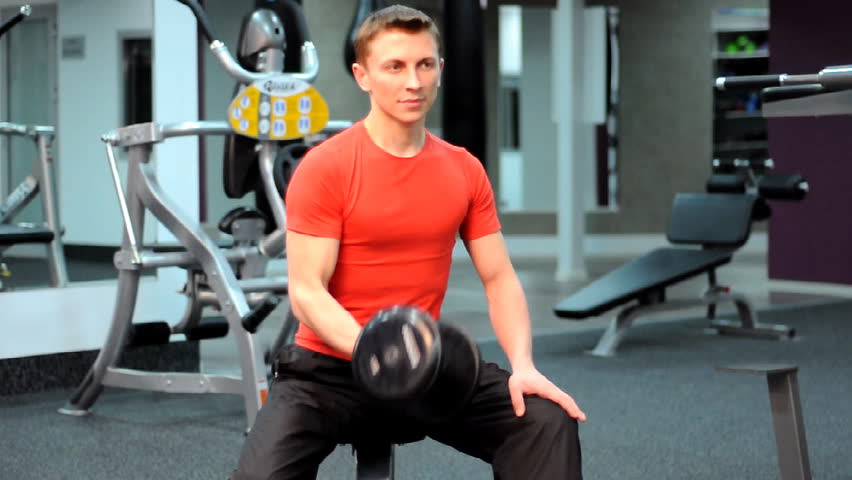 Man training in gym lift dumbbells