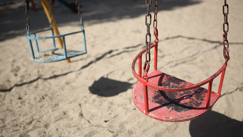 Empty old swings on a playground for children