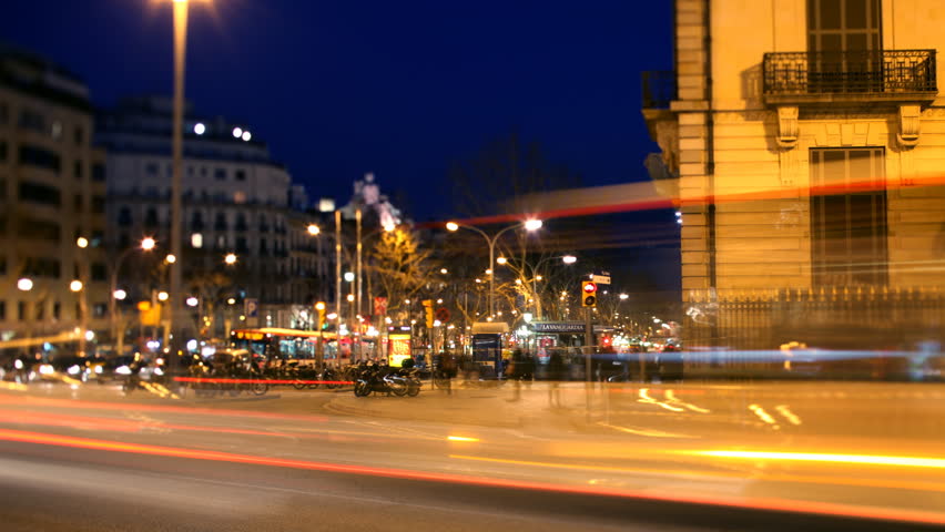 a pan across a street scene at dusk in barcelona , spain