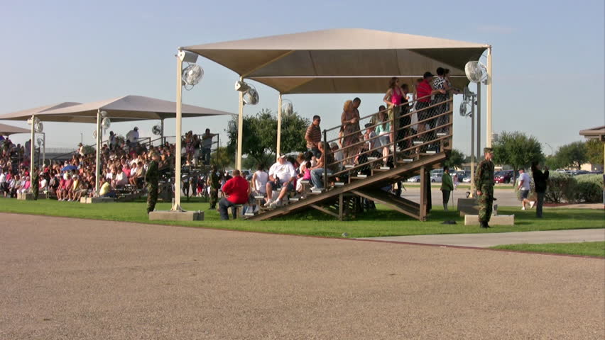 Video of USAF enlisted Basic Training graduates marching onto parade field for ceremony. Blue uniform with Drill Sergeants barking commands. Family watching. Lackland AFB San Antonio, Texas. 